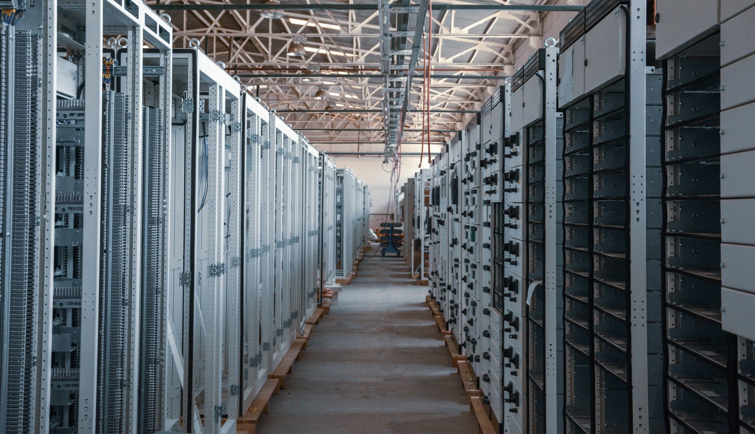 An aisle between rows of metal electrical control cabinets in a factory