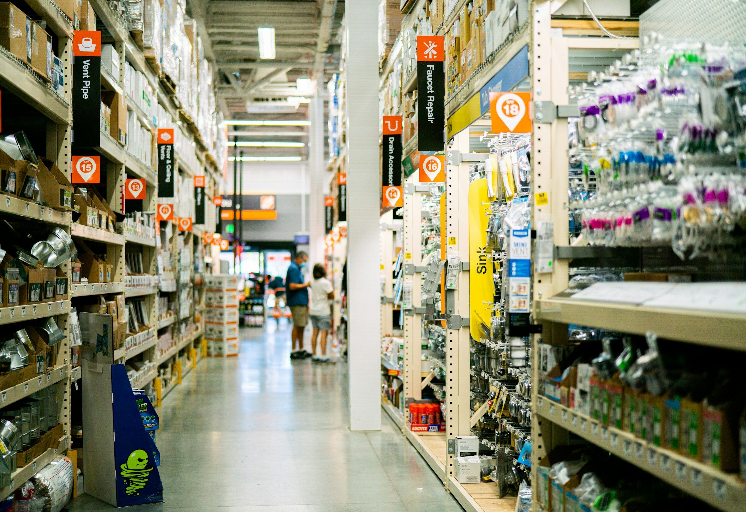 A store aisle lined with stocked shelves and numbered aisle signage