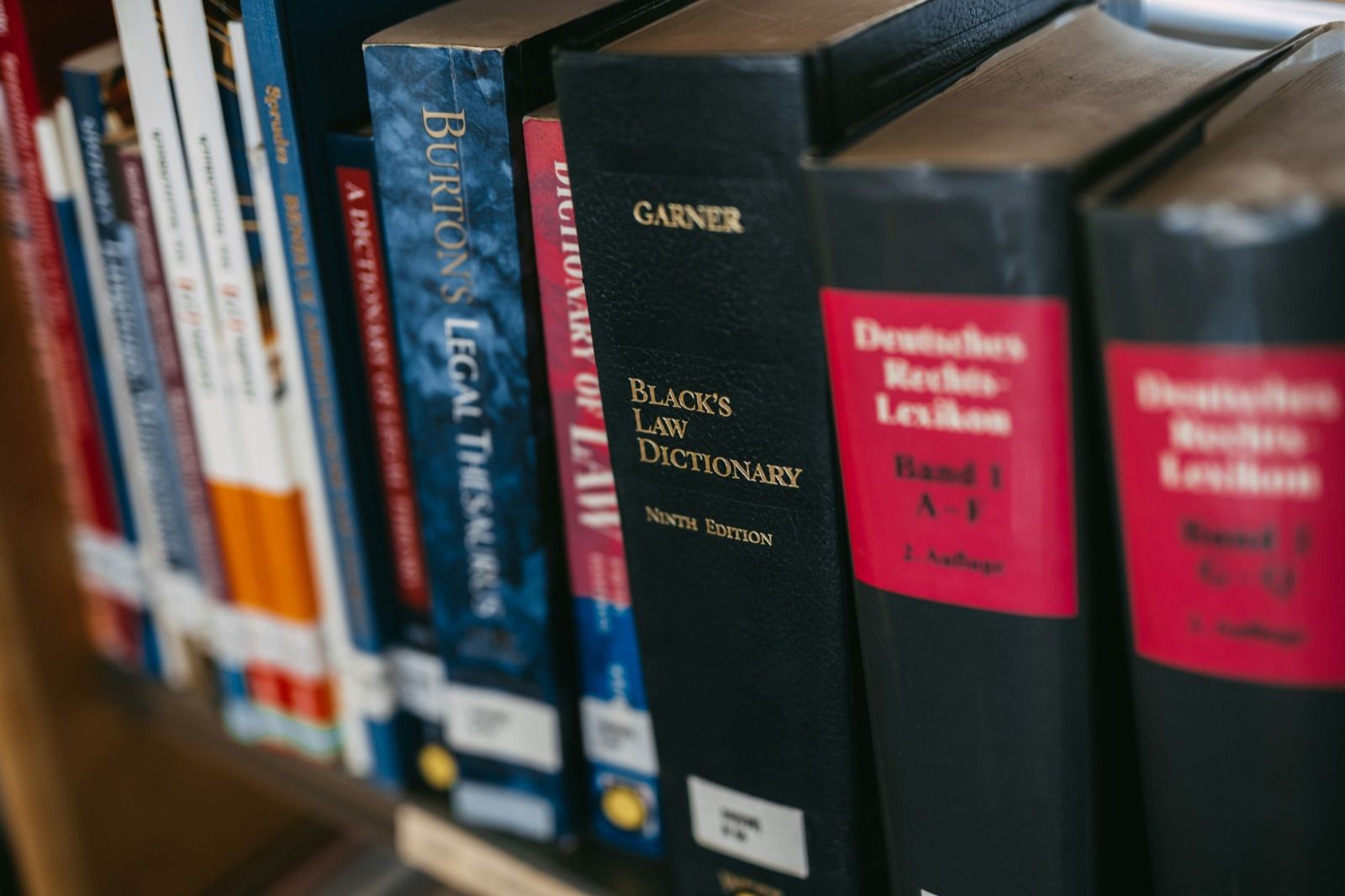 Bound legal reference volumes and law dictionaries standing on a shelf