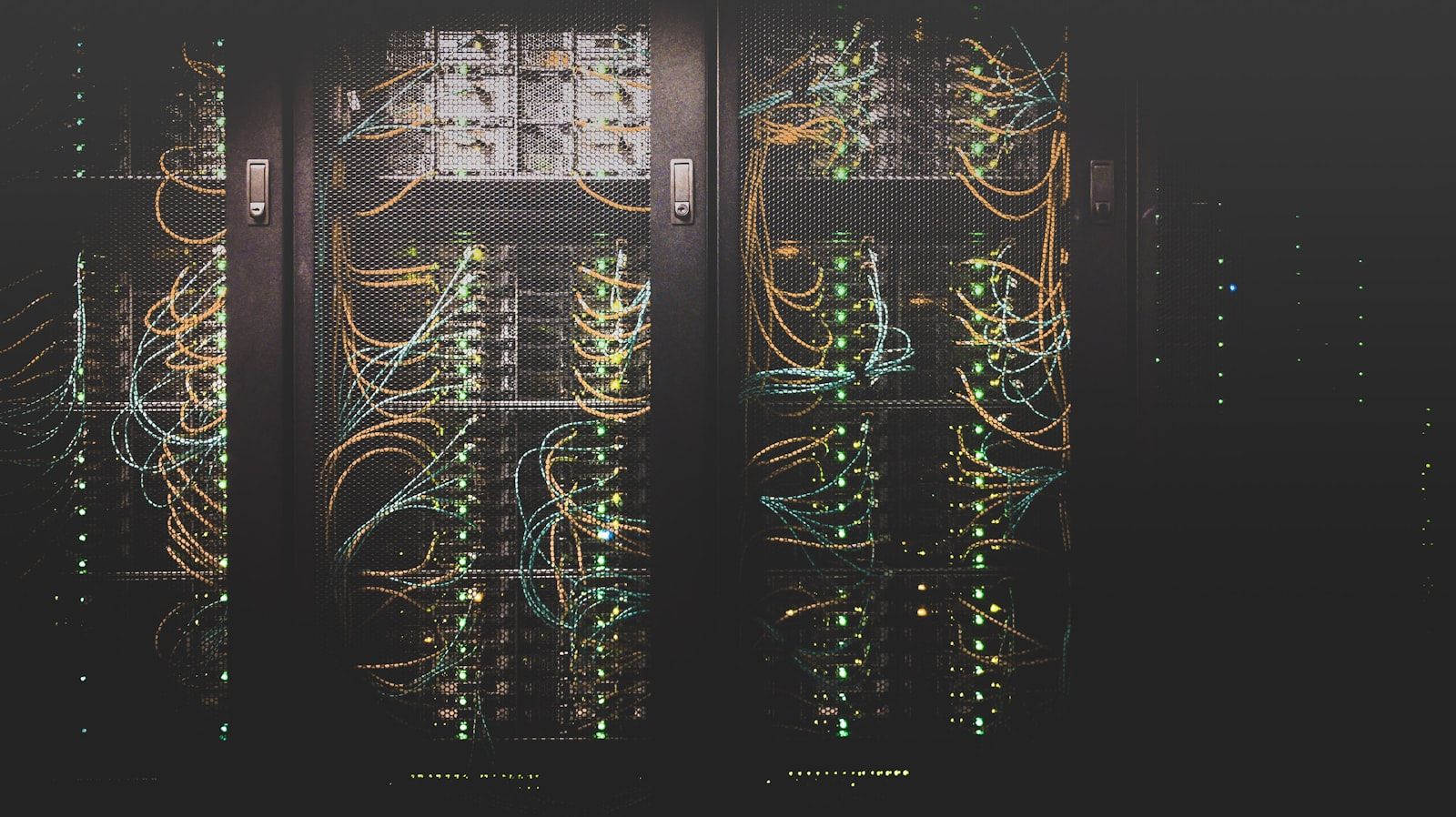 Cabling routed between rows of networking equipment in a dark server cabinet