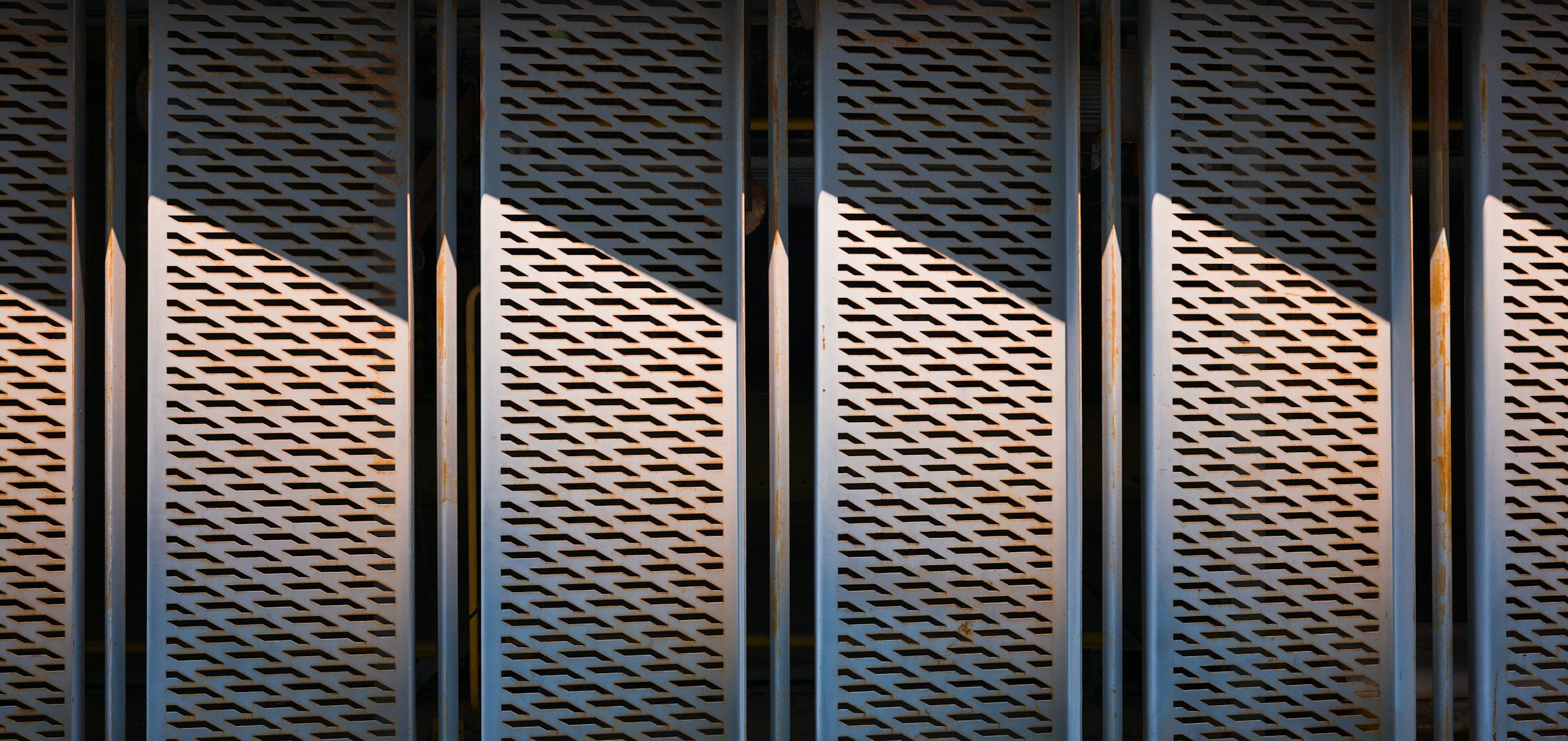 Rows of closely spaced parallel metal cooling fins on large industrial thermal equipment