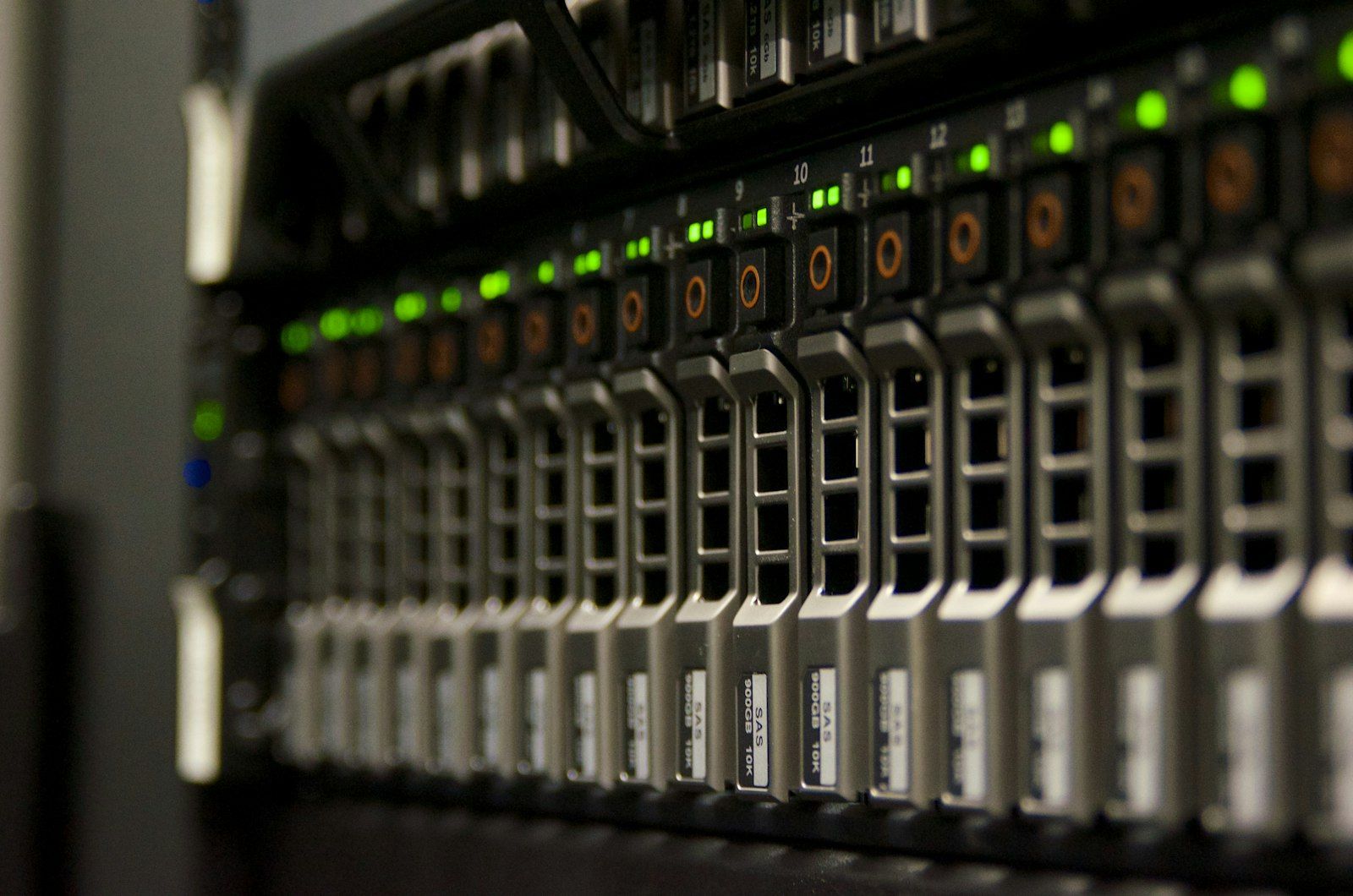 Close-up of a rack server's front drive bays, with green status lights glowing